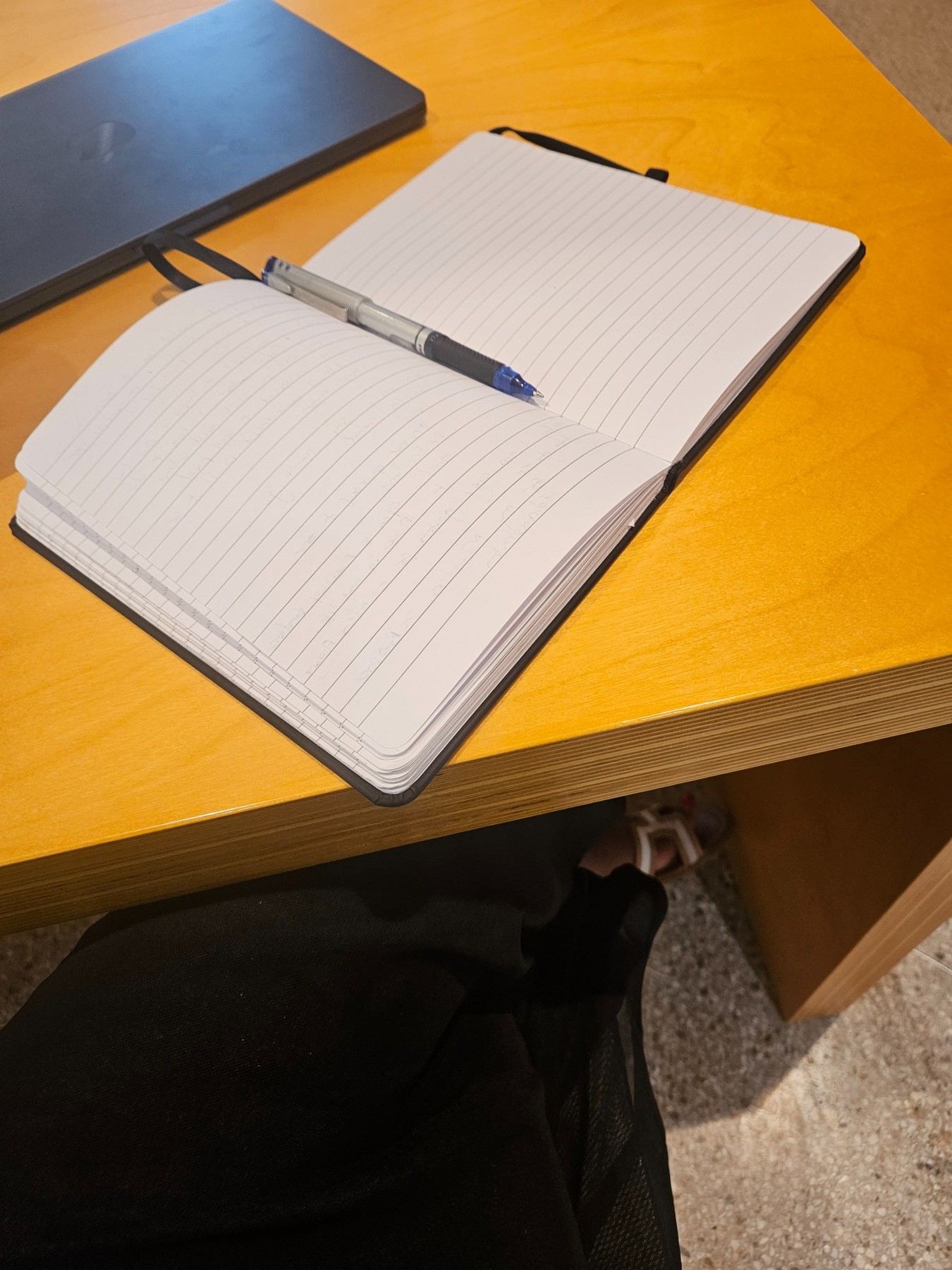 My open notebook and pen on a yellow cafe table